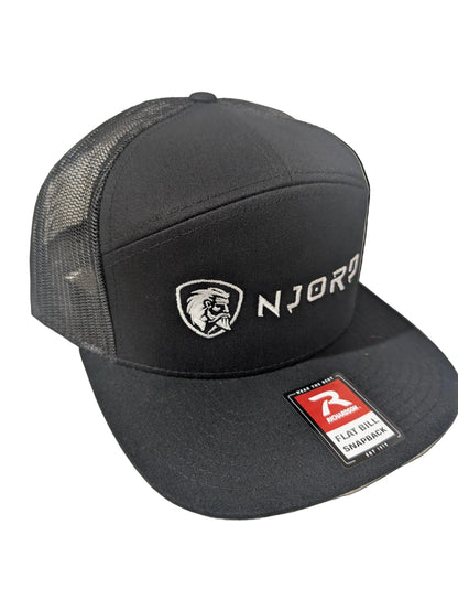 A black flat-brim trucker hat with black mesh back panels, featuring a white embroidered shield logo and the word 'NJORD' on the front, along with a red and white 'Flat Bill Sandwich' sticker on the brim.